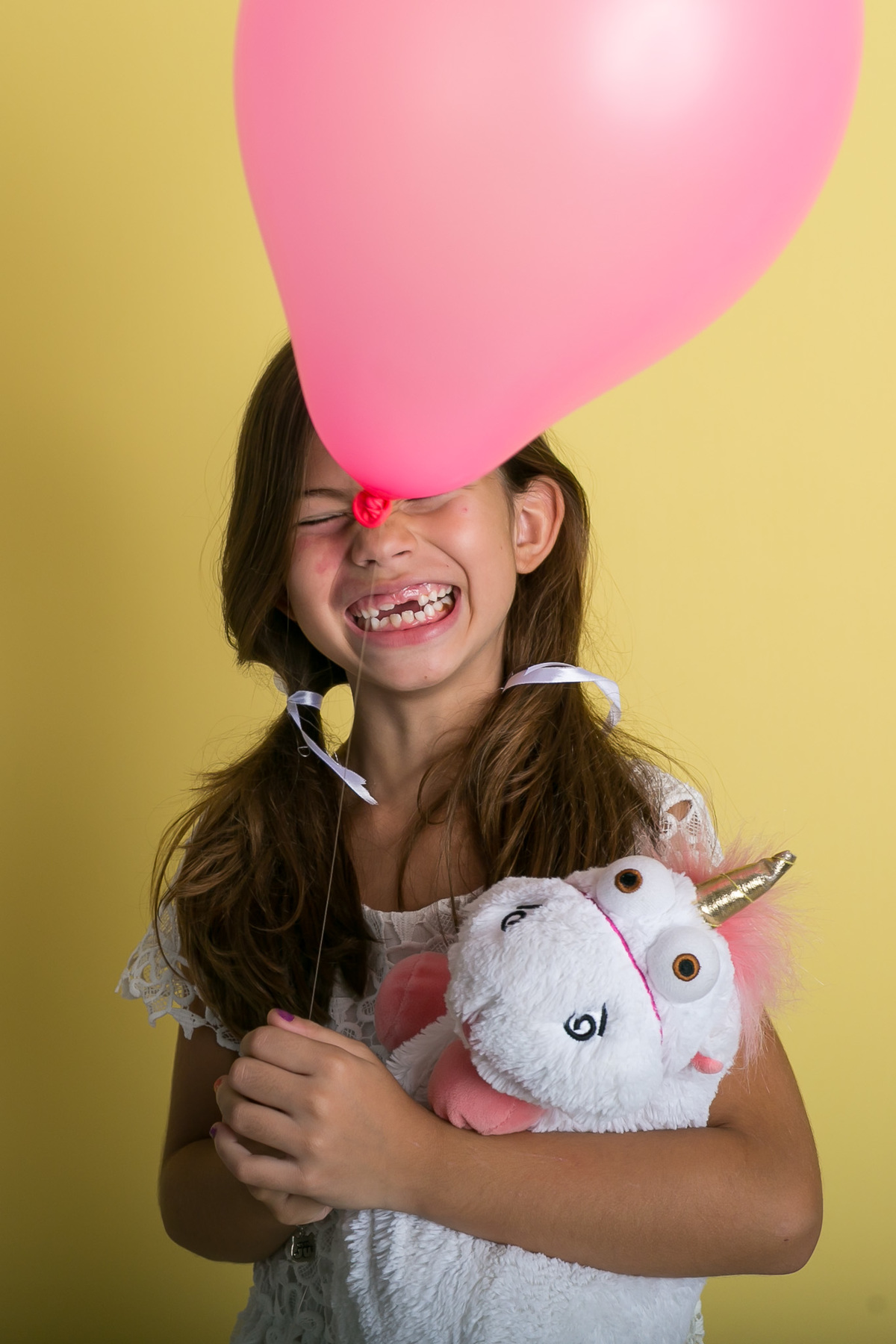 Sofia, um unicórinio, o sorriso banguela e o balão cor de rosa