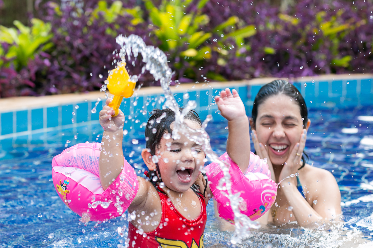 Maria fazendo bagunça na piscina com a mamãe