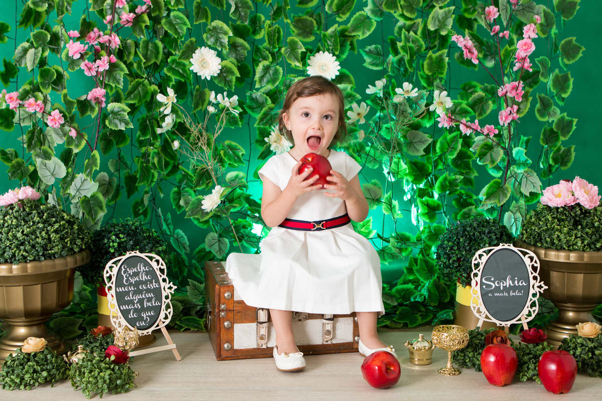 menina em Ensaio smash the cake comendo maça