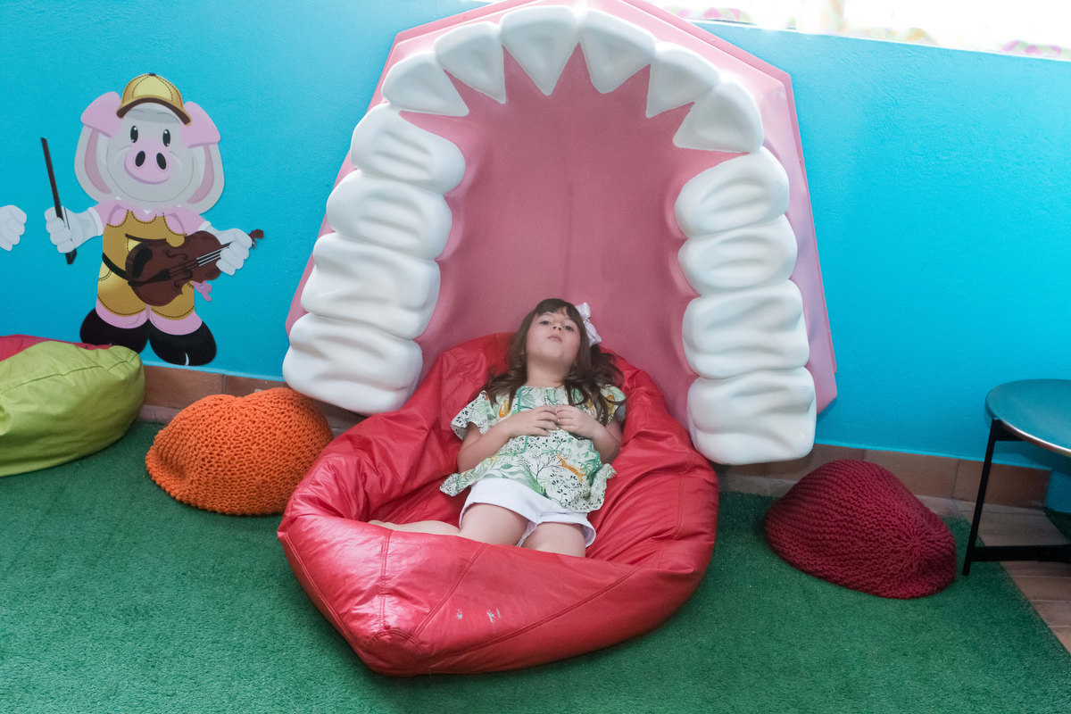 menina brincando na boca de dentista