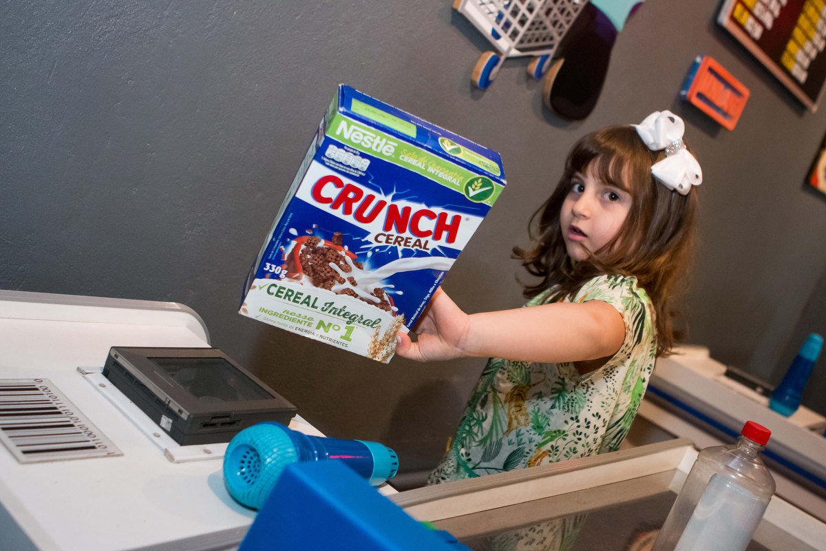 menina brincando de fazer compras, comprando cereal