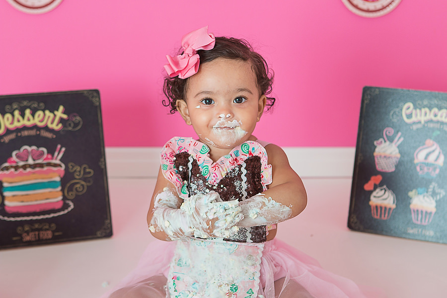 ensaio smash the cake com tema confeitaria ou doceria. Criança esmagando o bolo e curtindo o ensaio e festa de um ano.