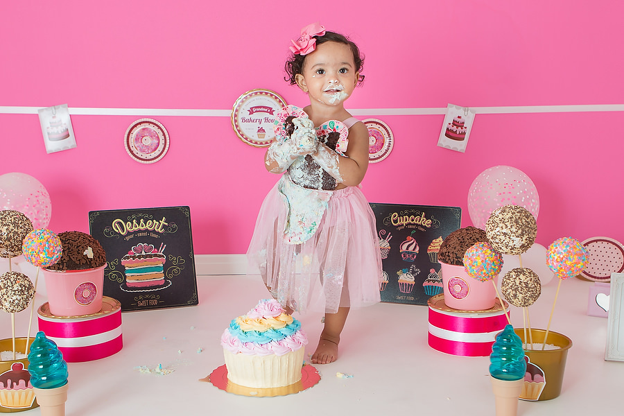 ensaio smash the cake com tema confeitaria ou doceria. Criança esmagando o bolo e curtindo o ensaio e festa de um ano.