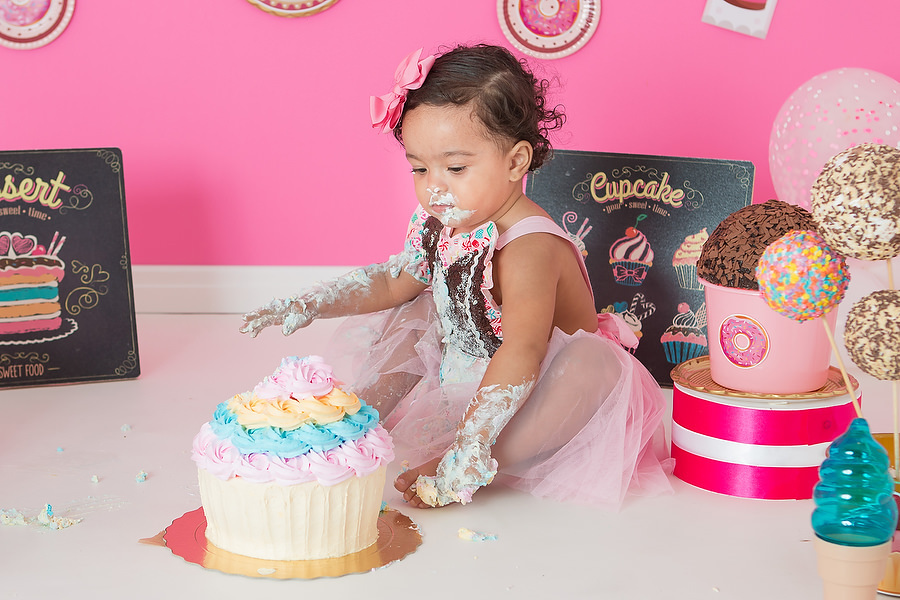 ensaio smash the cake com tema confeitaria ou doceria. Criança esmagando o bolo e curtindo o ensaio e festa de um ano.