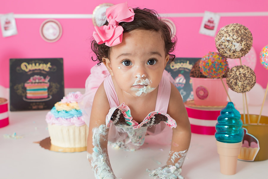 ensaio smash the cake com tema confeitaria ou doceria. Criança esmagando o bolo e curtindo o ensaio e festa de um ano.