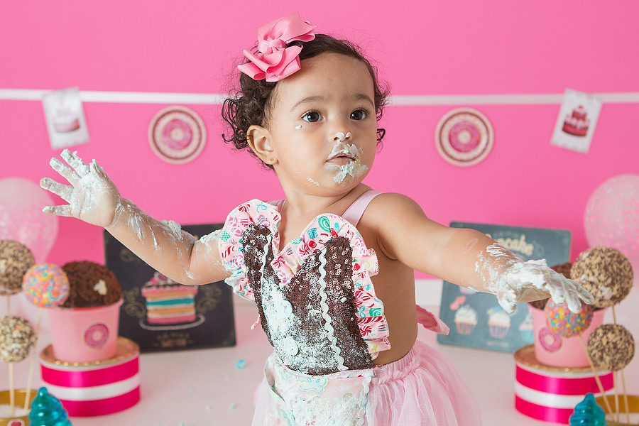 ensaio smash the cake com tema confeitaria ou doceria. Criança esmagando o bolo e curtindo o ensaio e festa de um ano.