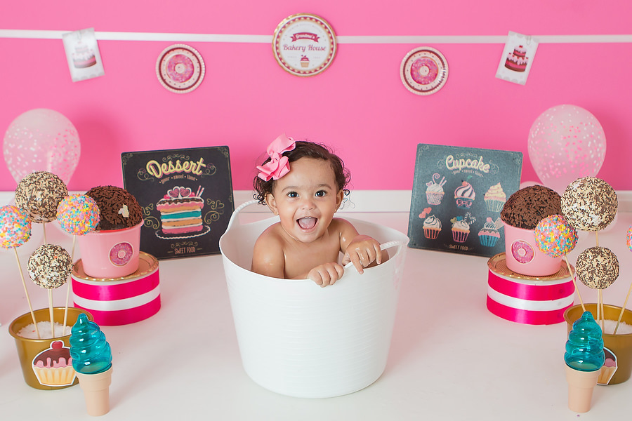 ensaio smash the cake com tema confeitaria ou doceria. Criança esmagando o bolo e curtindo o ensaio e festa de um ano.