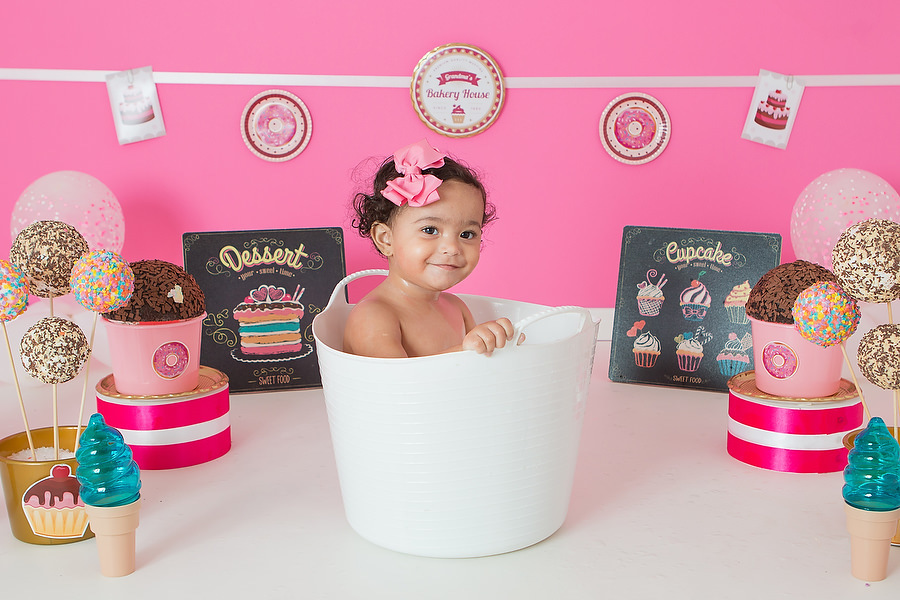 Criança feliz tomando banho após ensaio smash the cake. Tema do ensaio Confeitaria ou doceria.