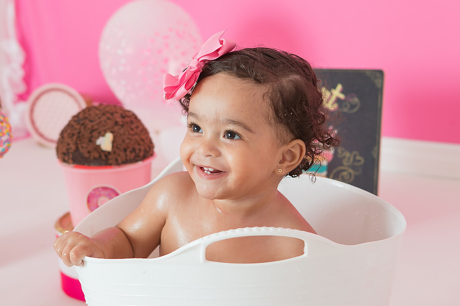 Criança feliz tomando banho após ensaio smash the cake. Tema do ensaio Confeitaria ou doceria.