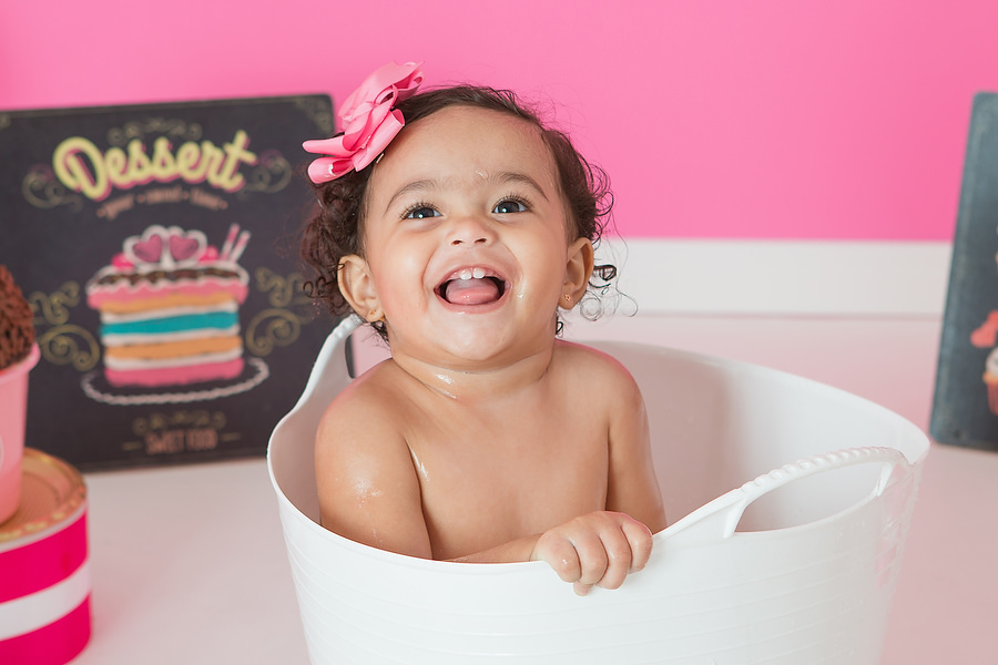 Criança feliz tomando banho após ensaio smash the cake. Tema do ensaio Confeitaria ou doceria.