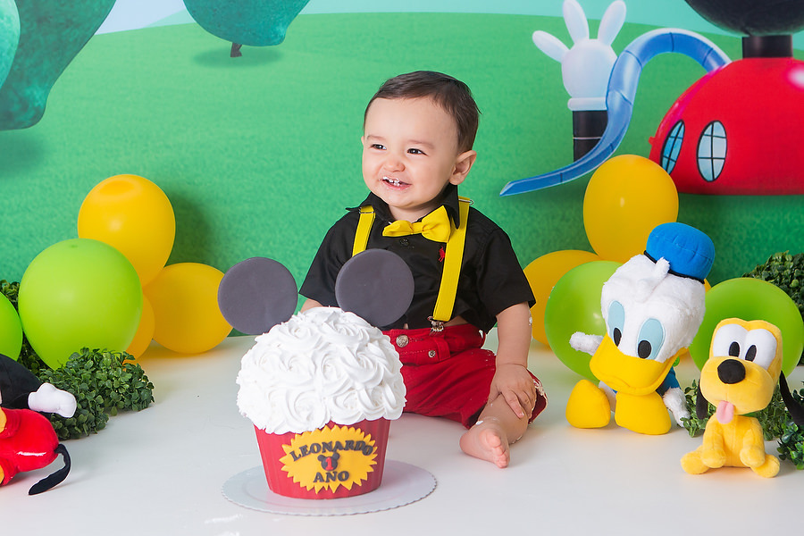ensaio smash the cake, com tema a casa do mickey mouse, com bolo temático, festa diferente para comemorar 1 ano, festa de 1 ano, esmagando o bolo. 