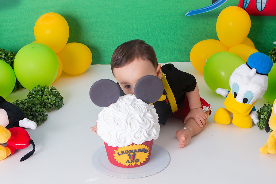 ensaio smash the cake, com tema a casa do mickey mouse, com bolo temático, festa diferente para comemorar 1 ano, festa de 1 ano, esmagando o bolo. 