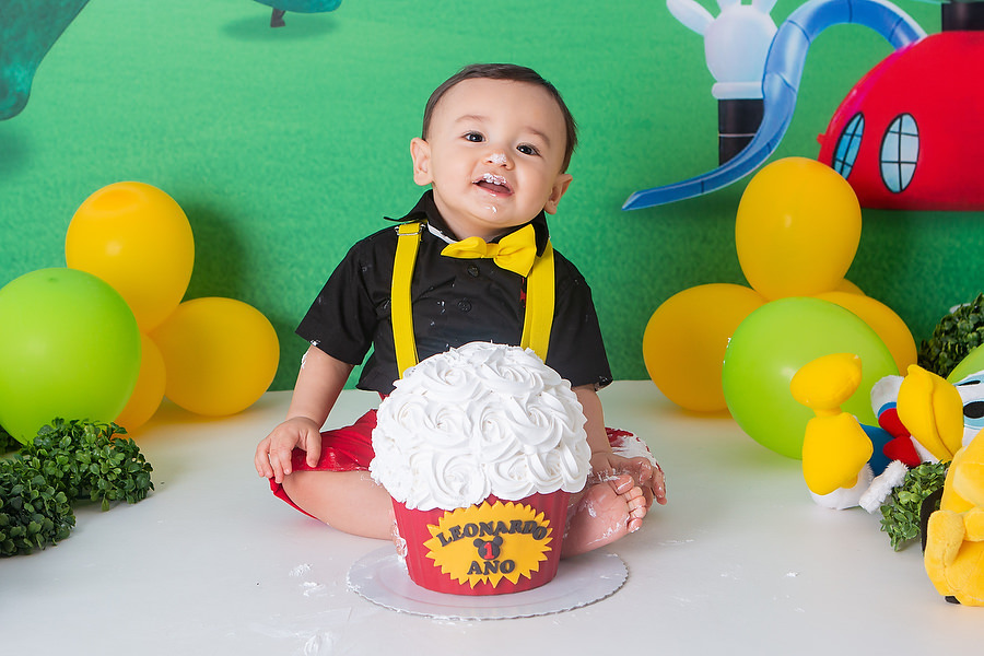 ensaio smash the cake, com tema a casa do mickey mouse, com bolo temático, festa diferente para comemorar 1 ano, festa de 1 ano, esmagando o bolo. 