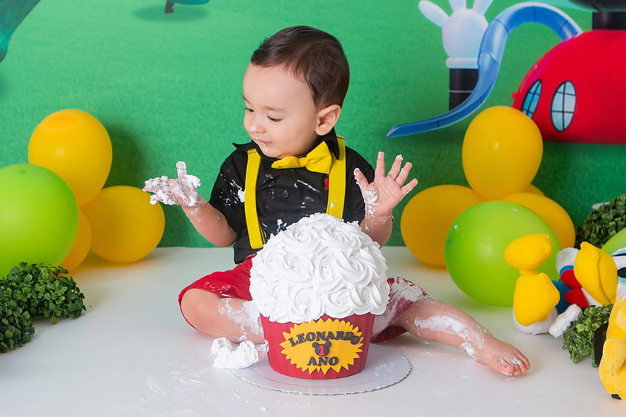 ensaio smash the cake, com tema a casa do mickey mouse, com bolo temático, festa diferente para comemorar 1 ano, festa de 1 ano, esmagando o bolo. 