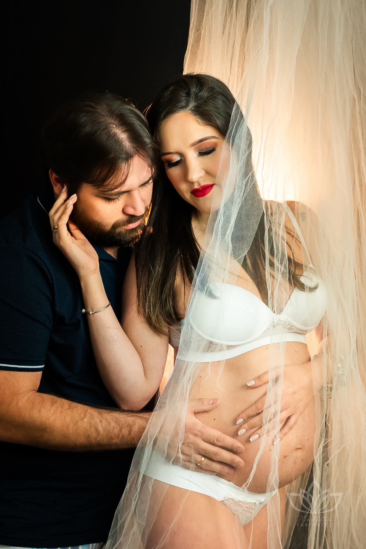 gestante vestindo langerie branca envolta em tule branco