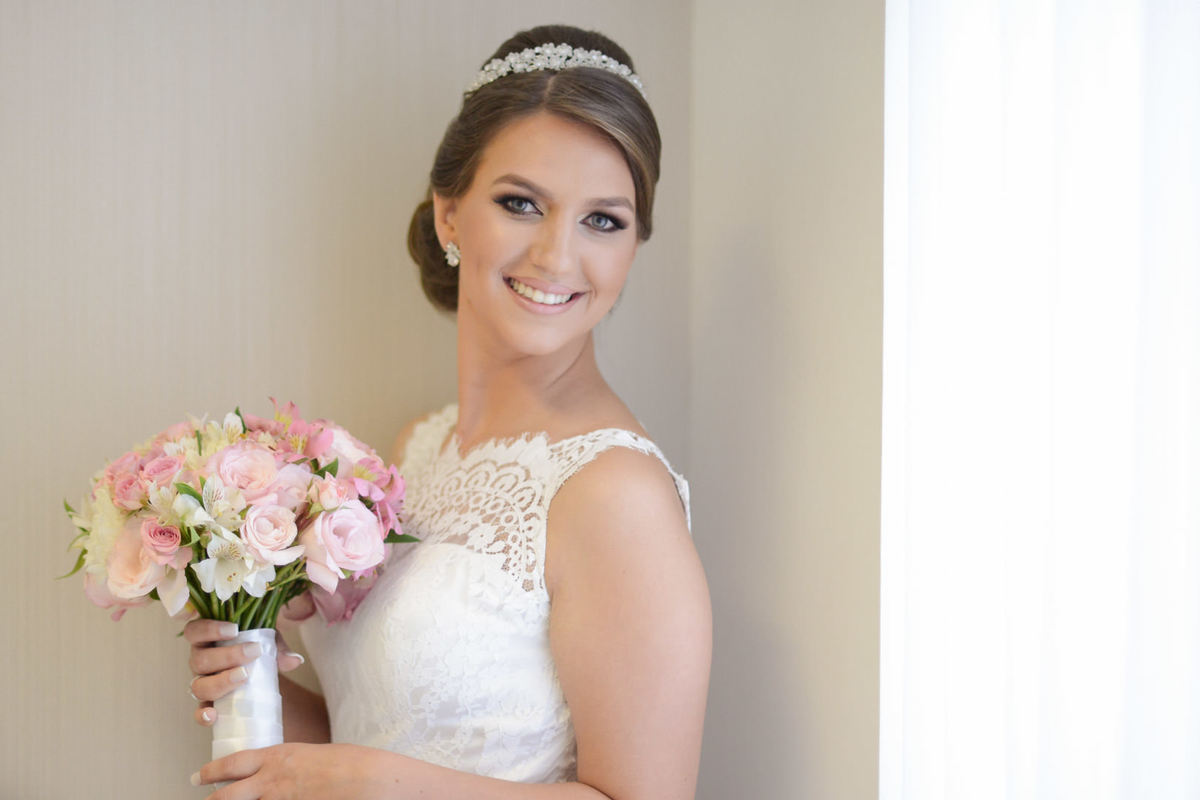 Making of da noiva no salão de belza Camaleão Cabelo e Estética em Campo Largo, fotografado pelo melhor fotógrafo de casamentos e ensaios de campo largo e Curitiba, Michel Druziki. Noiva sorrindo com o buquê de flores rosas