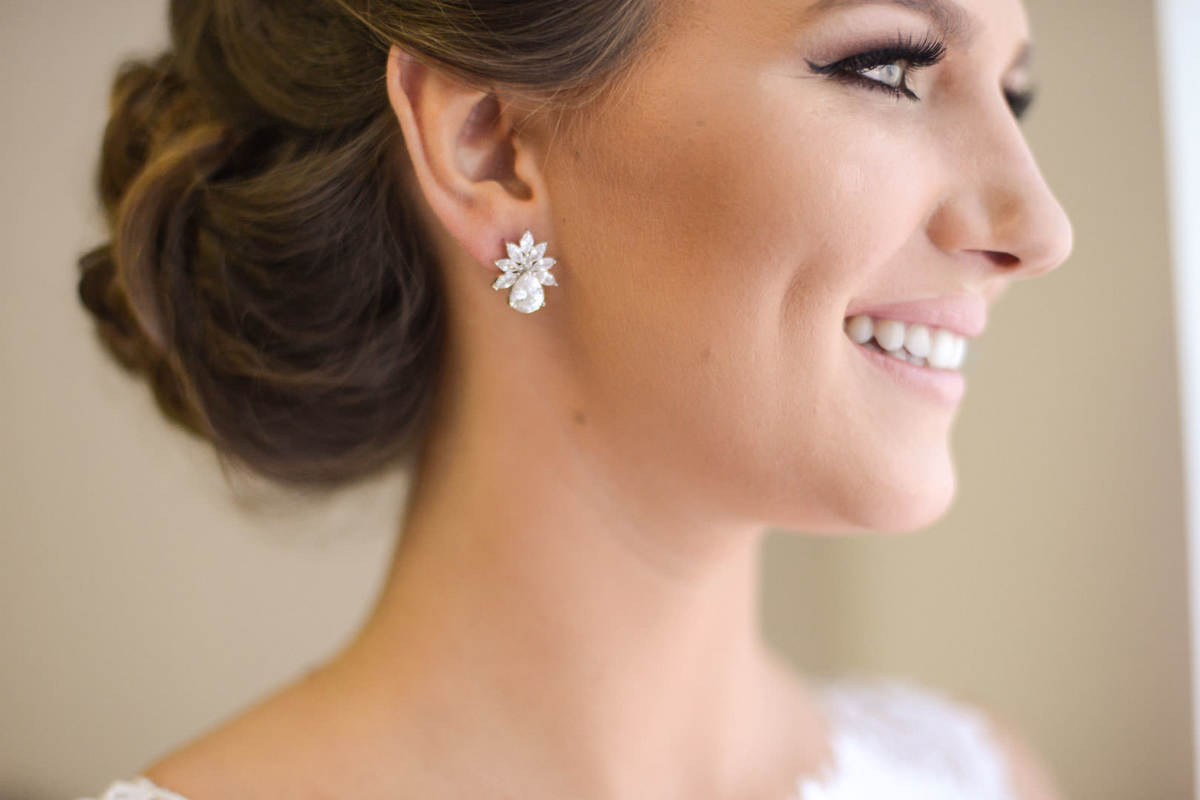 Making of da noiva no salão de belza Camaleão Cabelo e Estética em Campo Largo, fotografado pelo melhor fotógrafo de casamentos e ensaios de campo largo e Curitiba, Michel Druziki. Noiva de cabelo preso e brinco sorrindo