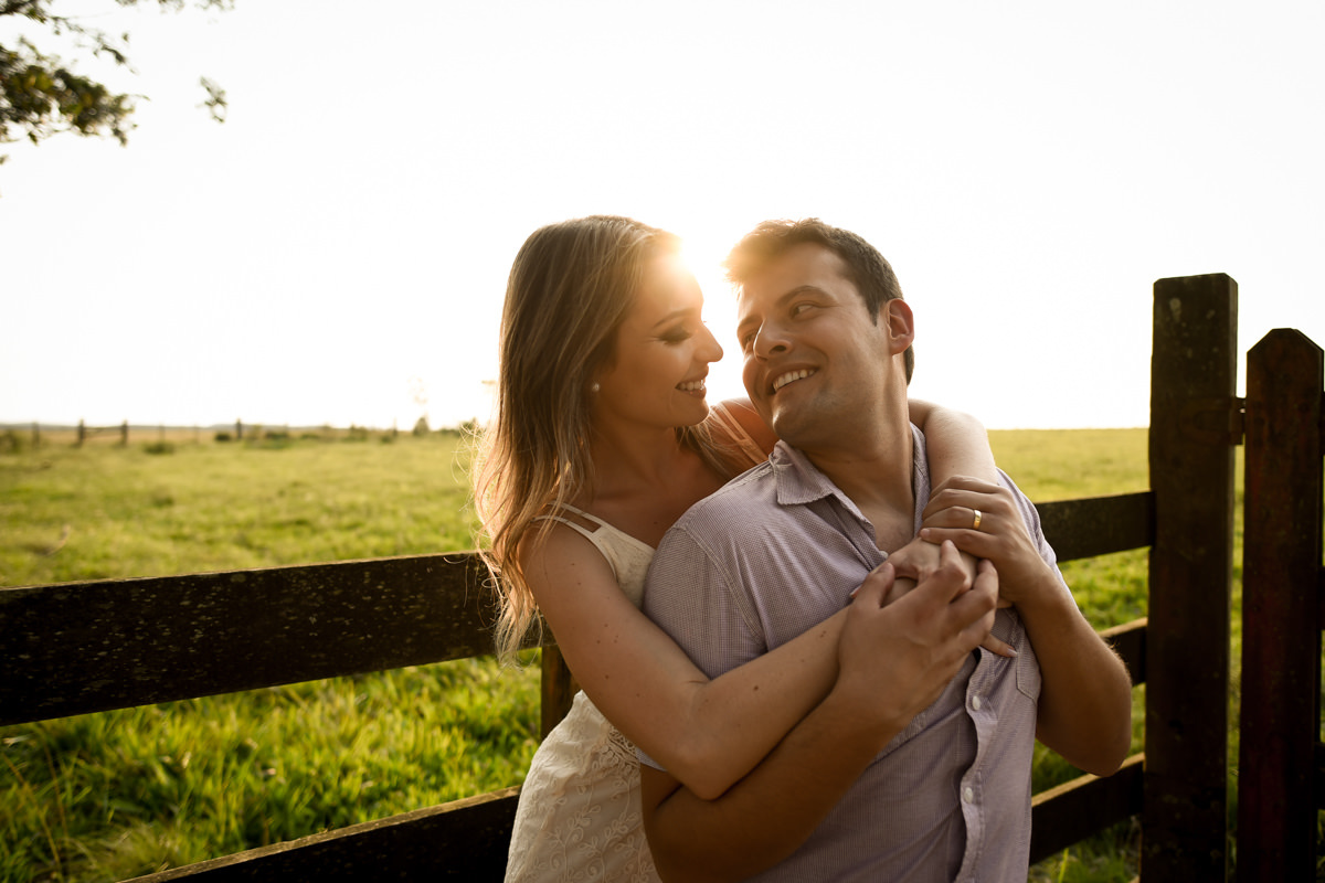 Ensaio de casamento pelo melhor fotógrafo de Campo Largo e Curitiba, Michel Druziki. Noivos encostados na cerca abraçados no por do sol