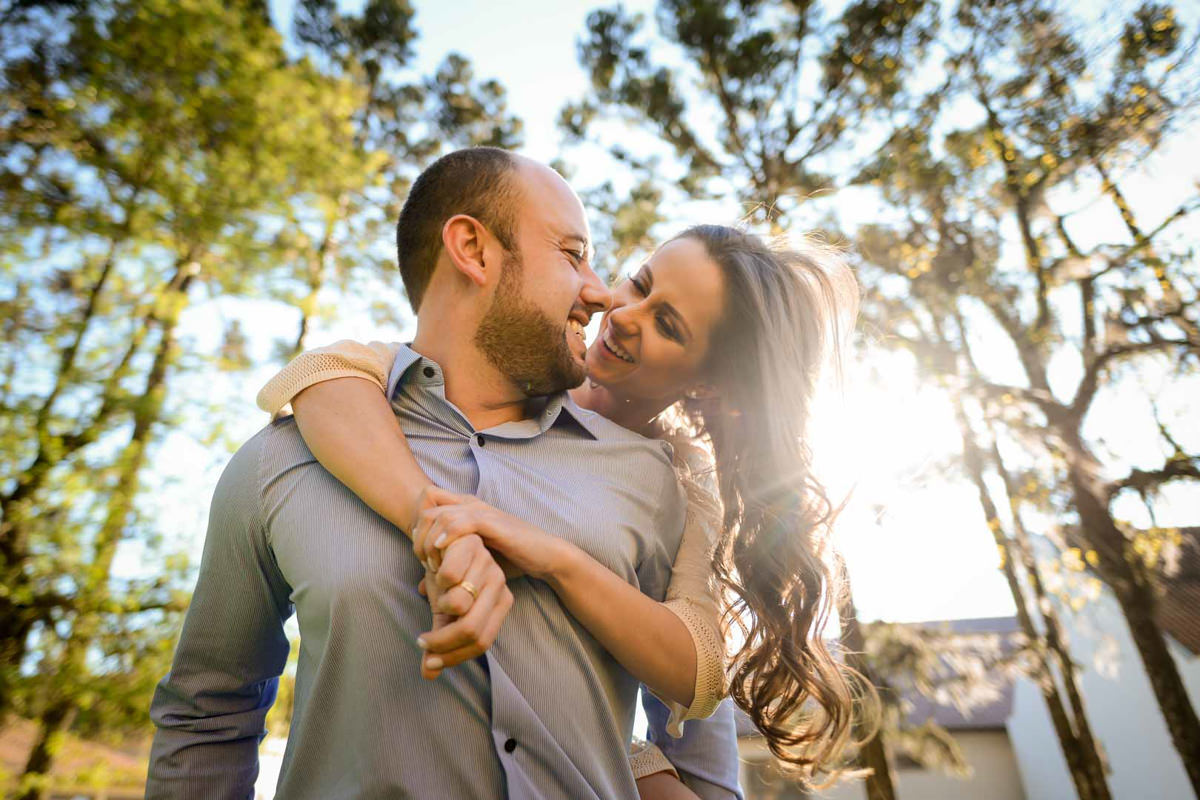 Ensaio pre wedding do casal Larissa e Cícero fotografado pelo melhor fotógrafo de ensaios e casamento em Campo Largo e Curitiba, Michel Druziki. Noivos sorrindo com raio de sol