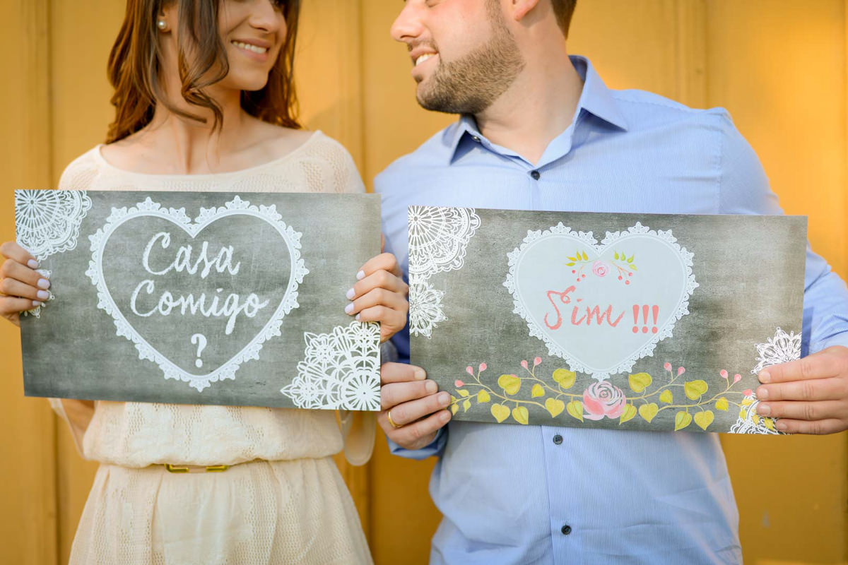 Ensaio pre wedding do casal Larissa e Cícero fotografado pelo melhor fotógrafo de ensaios e casamento em Campo Largo e Curitiba, Michel Druziki. Noivos segurando placa casa comigo?