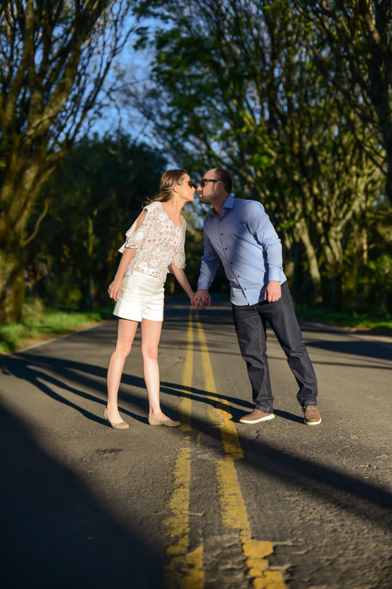 Ensaio pre wedding do casal Larissa e Cícero fotografado pelo melhor fotógrafo de ensaios e casamento em Campo Largo e Curitiba, Michel Druziki. Noivos se beijando no meio da estrada