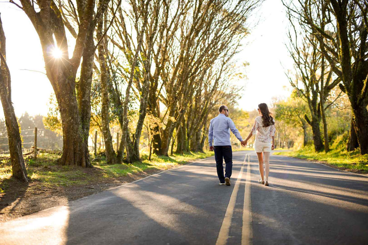 Ensaio pre wedding do casal Larissa e Cícero fotografado pelo melhor fotógrafo de ensaios e casamento em Campo Largo e Curitiba, Michel Druziki. Noivos caminhando de mãos dadas no meio da rua