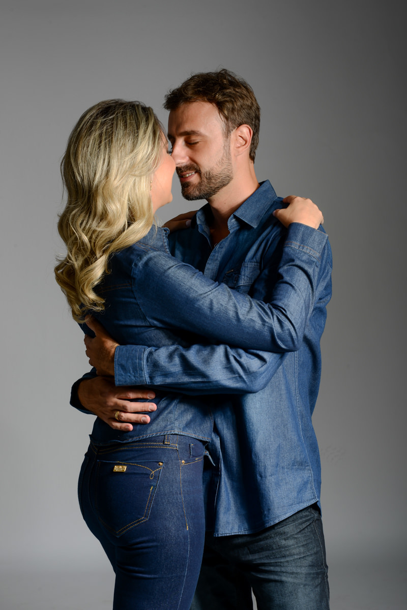 Ensaio de pre wedding em estúdio do lindo casal Mariane e Eduardo, fotografado pelo fotógrafo de ensaios e casamento em Campo Largo e Curitiba, Michel Druziki. Noivos de jeans abraçados e sorrindo de olhos fechados