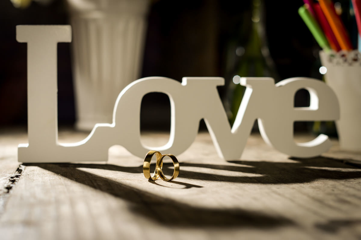 Casamento dos noivos Anna e Bruno ao ar livre em um dia lindo, na região de Curitiba e Campo Largo, fotografado pelo fotógrafo de casamentos Michel Druziki. Alianças e a palavra love de madeira