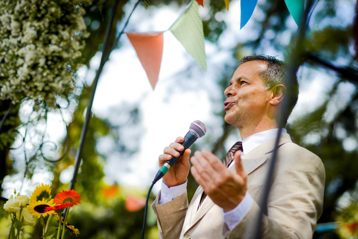 Casamento dos noivos Anna e Bruno ao ar livre em um dia lindo, na região de Curitiba e Campo Largo, fotografado pelo fotógrafo de casamentos Michel Druziki. Pastor realizando a cerimônia em meio às arvores