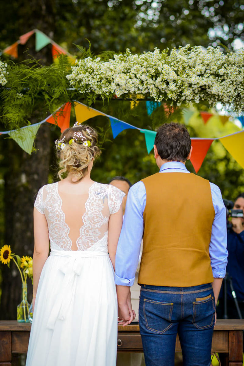 Casamento dos noivos Anna e Bruno ao ar livre em um dia lindo, na região de Curitiba e Campo Largo, fotografado pelo fotógrafo de casamentos Michel Druziki. Noivos de costas e de mãos dadas durante a cerimônia