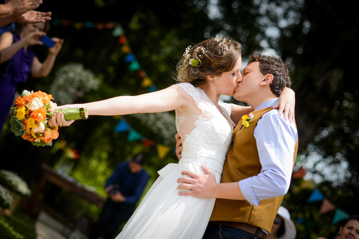 Casamento dos noivos Anna e Bruno ao ar livre em um dia lindo, na região de Curitiba e Campo Largo, fotografado pelo fotógrafo de casamentos Michel Druziki. Noivos se beijando na saída da cerimônia