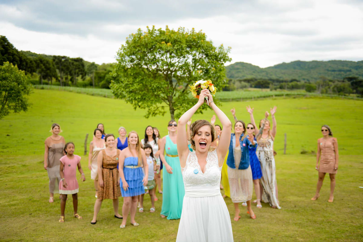 Casamento dos noivos Anna e Bruno ao ar livre em um dia lindo, na região de Curitiba e Campo Largo, fotografado pelo fotógrafo de casamentos Michel Druziki. Noiva jogando buquê