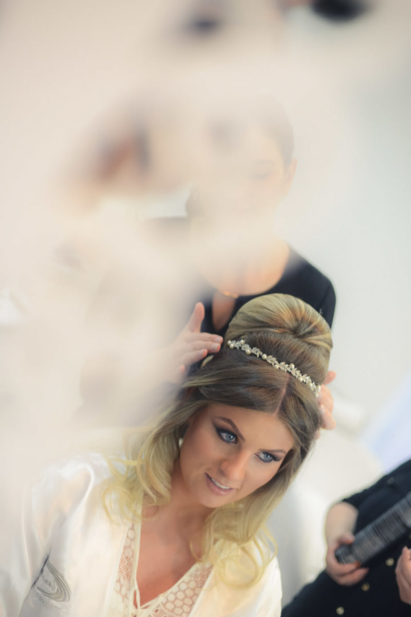 Making of da noiva no salão de belza Camaleão Cabelo e Estética em Campo Largo, fotografado pelo melhor fotógrafo de casamentos e ensaios de campo largo e Curitiba, Michel Druziki. Noiva colocando a tiara e olhando no espelho