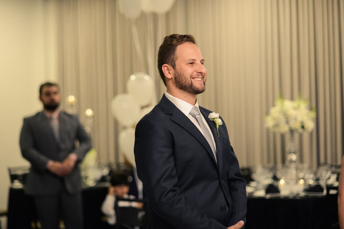 Casamento dos noivos Dani e Léo, fotografado pelo melhor fotógrafo de casamentos de campo largo e Curitiba, Michel Druziki. Noivo sorrindo esperando noiva