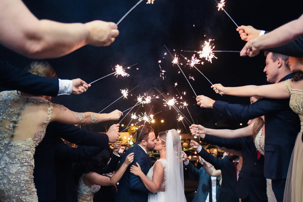 Casamento dos noivos Dani e Léo, fotografado pelo melhor fotógrafo de casamentos de campo largo e Curitiba, Michel Druziki. Noivos passando pelo túnel de convidados com vela chuva de prataCasamento dos noivos Dani e Léo, fotografado pelo melhor fotógrafo 
