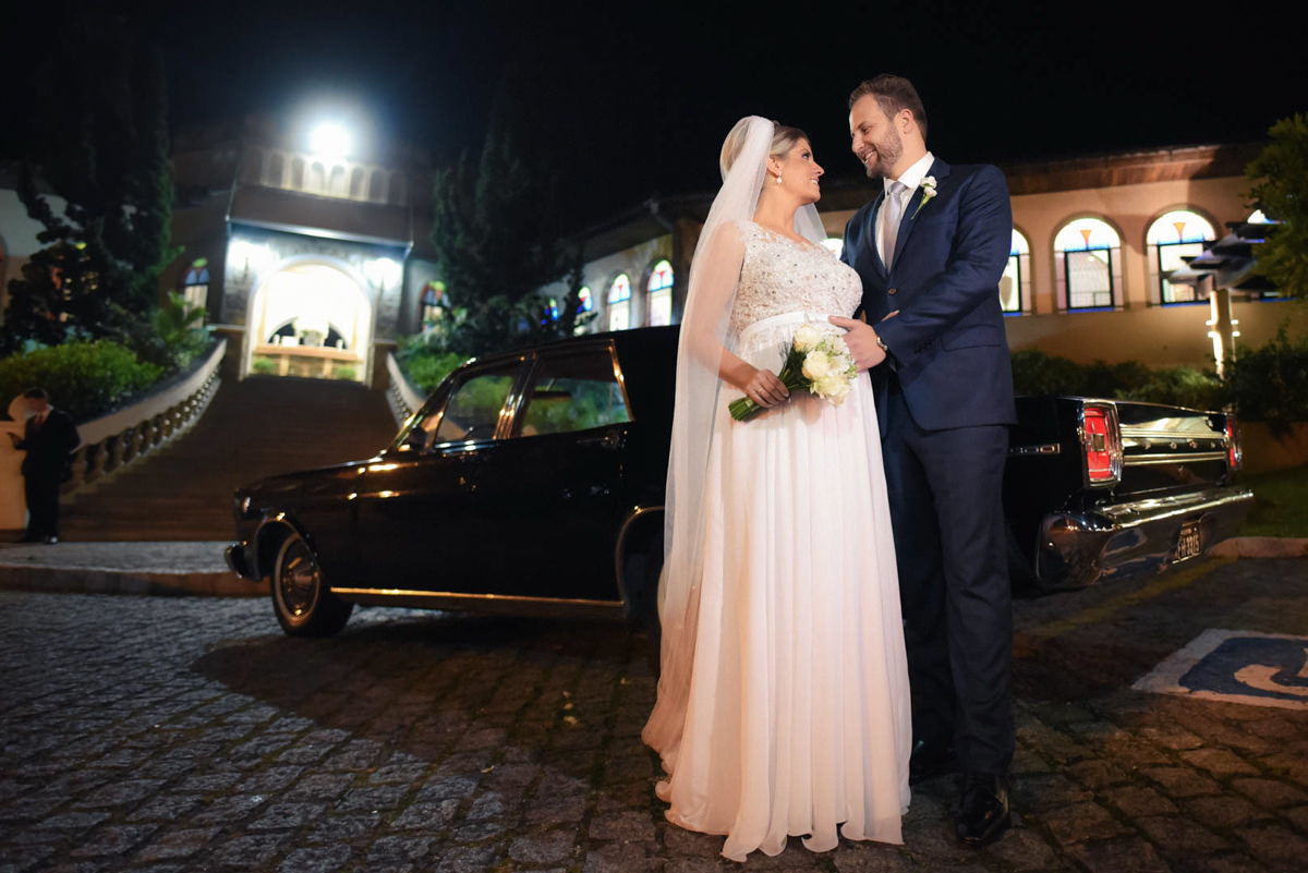 Casamento dos noivos Dani e Léo, fotografado pelo melhor fotógrafo de casamentos de campo largo e Curitiba, Michel Druziki. Noivos abraçados em frente ao carro