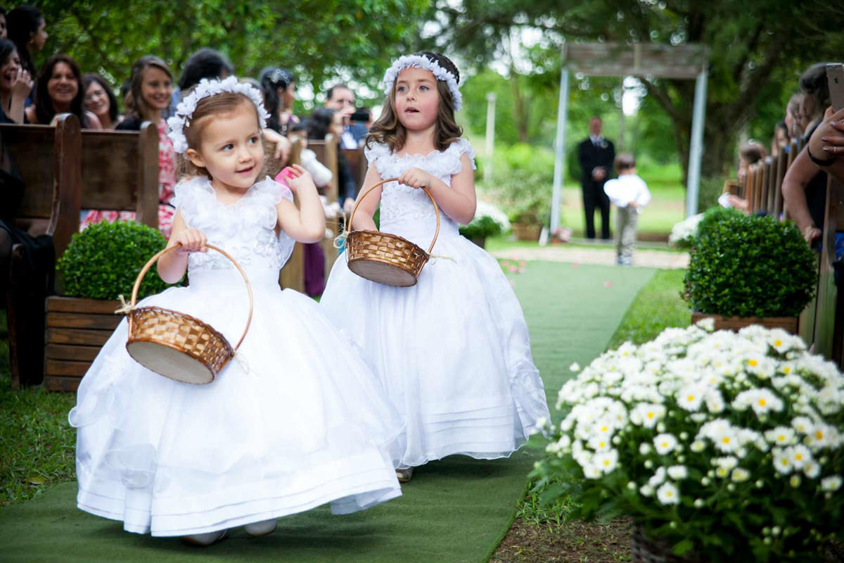 Casamento ao ar livre e de dia dos noivos Anny e Rodolfo fotografado pelo melhor fotógrafo de Campo Largo e região de Curitiba, Michel Druziki. Daminhas jogando pétalas de flores