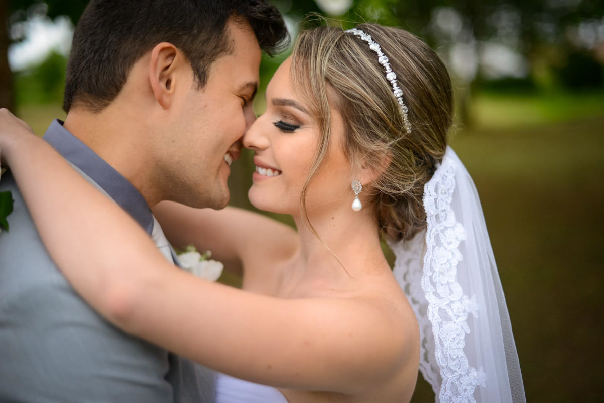 Casamento ao ar livre e de dia dos noivos Anny e Rodolfo fotografado pelo melhor fotógrafo de Campo Largo e região de Curitiba, Michel Druziki. Noivos abraçados, de olhos fechados e com nariz encostados