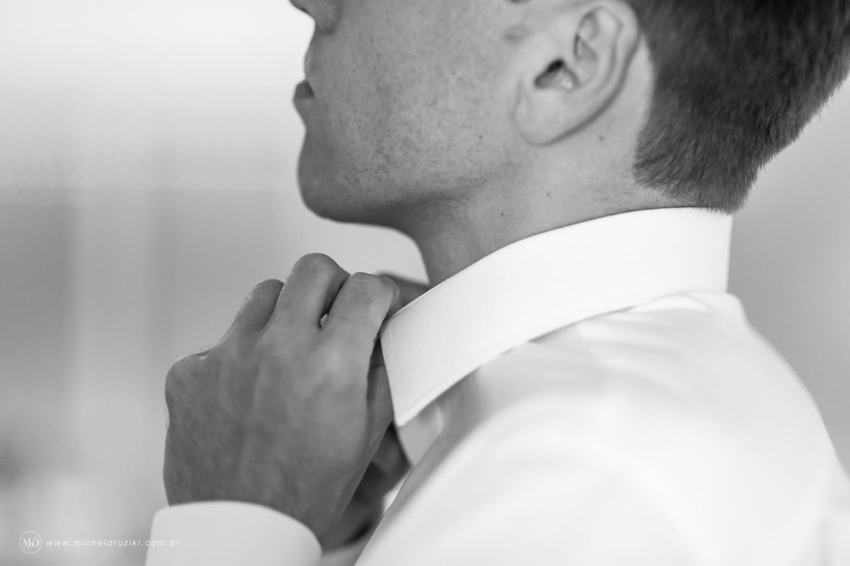 Casamento na praia do casal Dani e André fotografado pelo melhor fotógrafo de casamentos e ensaios de campo largo e Curitiba, Michel Druziki. Noivo fechando a camisa