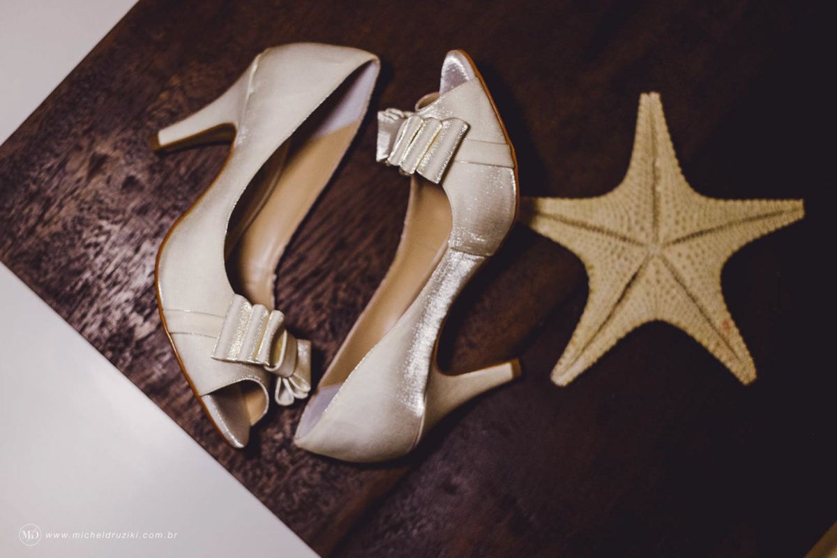 Casamento na praia do casal Dani e André fotografado pelo melhor fotógrafo de casamentos e ensaios de campo largo e Curitiba, Michel Druziki. sapatos da noiva com estrela do mar