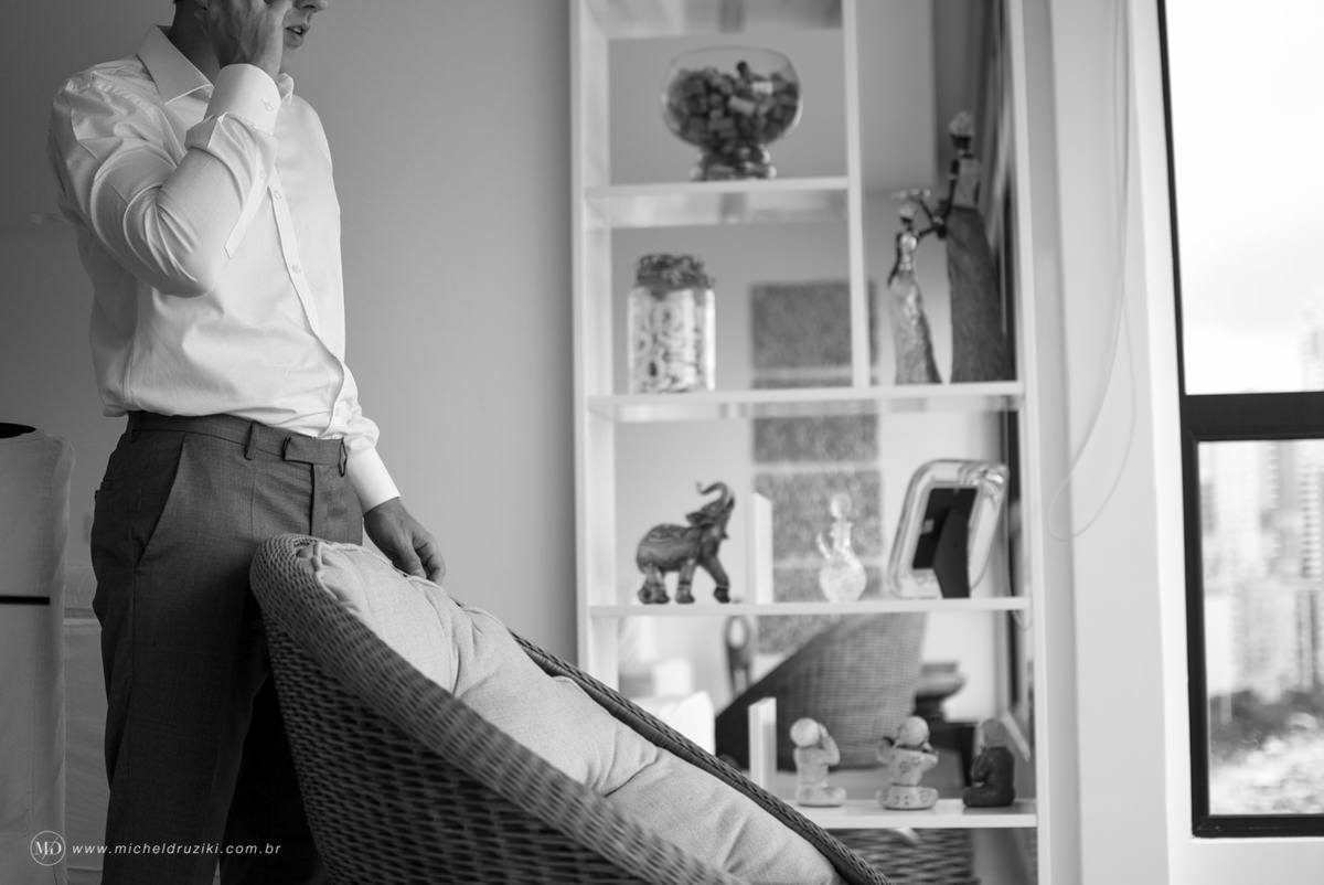 Casamento na praia do casal Dani e André fotografado pelo melhor fotógrafo de casamentos e ensaios de campo largo e Curitiba, Michel Druziki. Noivo falando no telefone