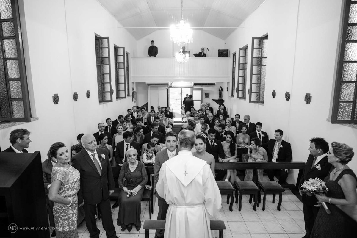 Casamento na praia do casal Dani e André fotografado pelo melhor fotógrafo de casamentos e ensaios de campo largo e Curitiba, Michel Druziki. Celebração da missa na igreja pequena e intimista