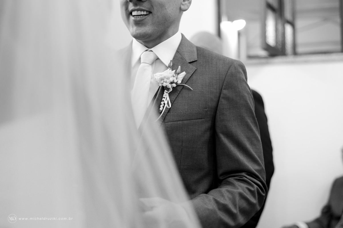 Casamento na praia do casal Dani e André fotografado pelo melhor fotógrafo de casamentos e ensaios de campo largo e Curitiba, Michel Druziki. Sorriso do noivo durante a celebração do casamento