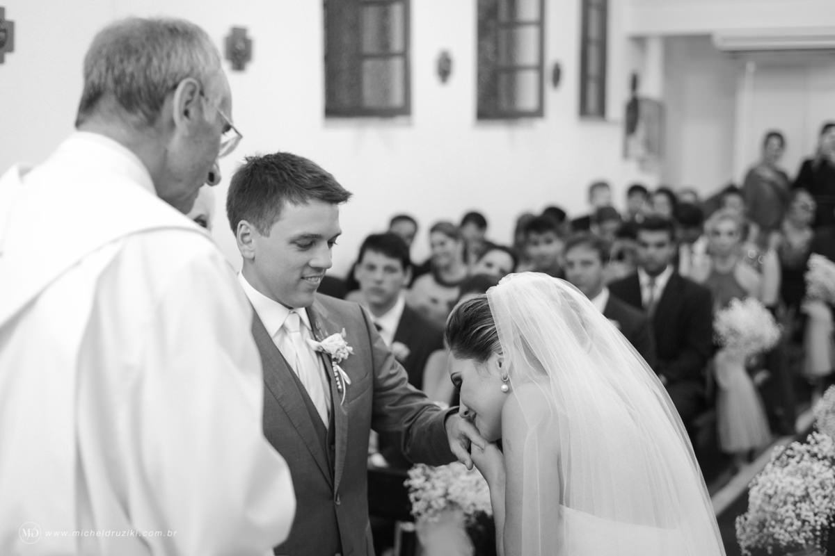 Casamento na praia do casal Dani e André fotografado pelo melhor fotógrafo de casamentos e ensaios de campo largo e Curitiba, Michel Druziki. Noiva encostando o rosto na aliança do noivo