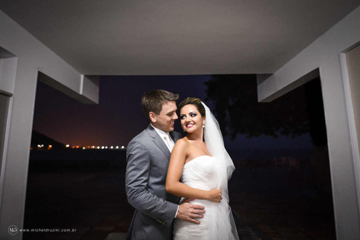 Casamento na praia do casal Dani e André fotografado pelo melhor fotógrafo de casamentos e ensaios de campo largo e Curitiba, Michel Druziki. Noivos abraçados e sorrindo