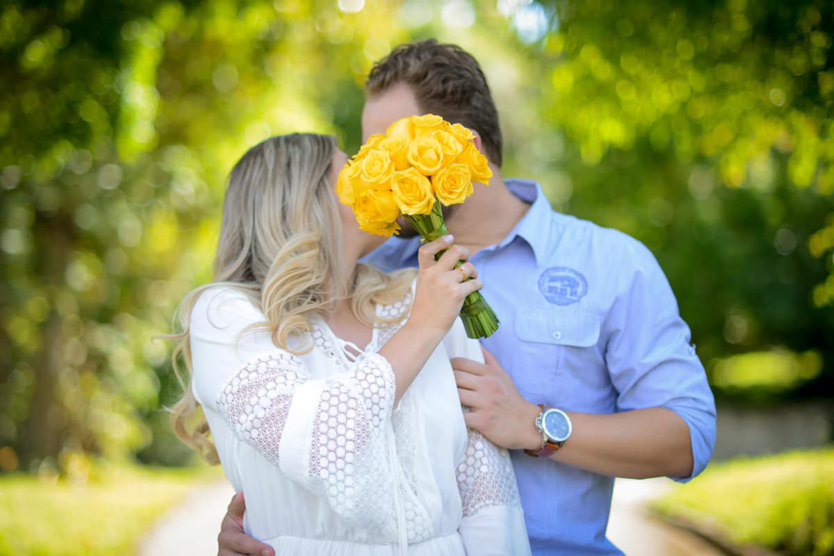 Ensaio de casal gestante em casa com cachorro fotografado pelo melhor fotógrafo de casamentos e ensaios de campo largo e Curitiba, Michel Druziki. Noivos se beijando e noiva escondendo o rosto com buquê amarelo
