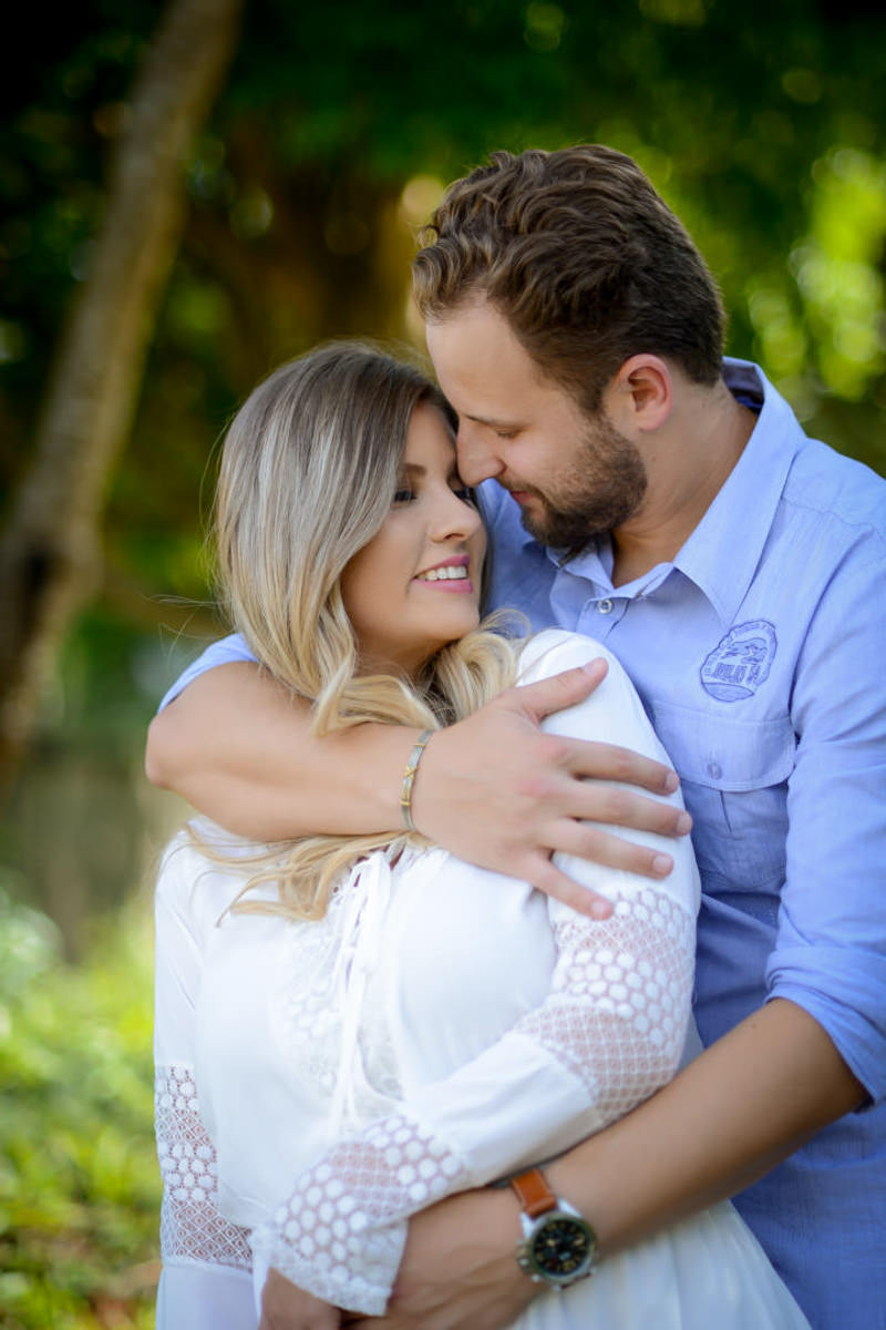 Ensaio de casal gestante em casa com cachorro fotografado pelo melhor fotógrafo de casamentos e ensaios de campo largo e Curitiba, Michel Druziki. Noivos abraçados e sorrindo 