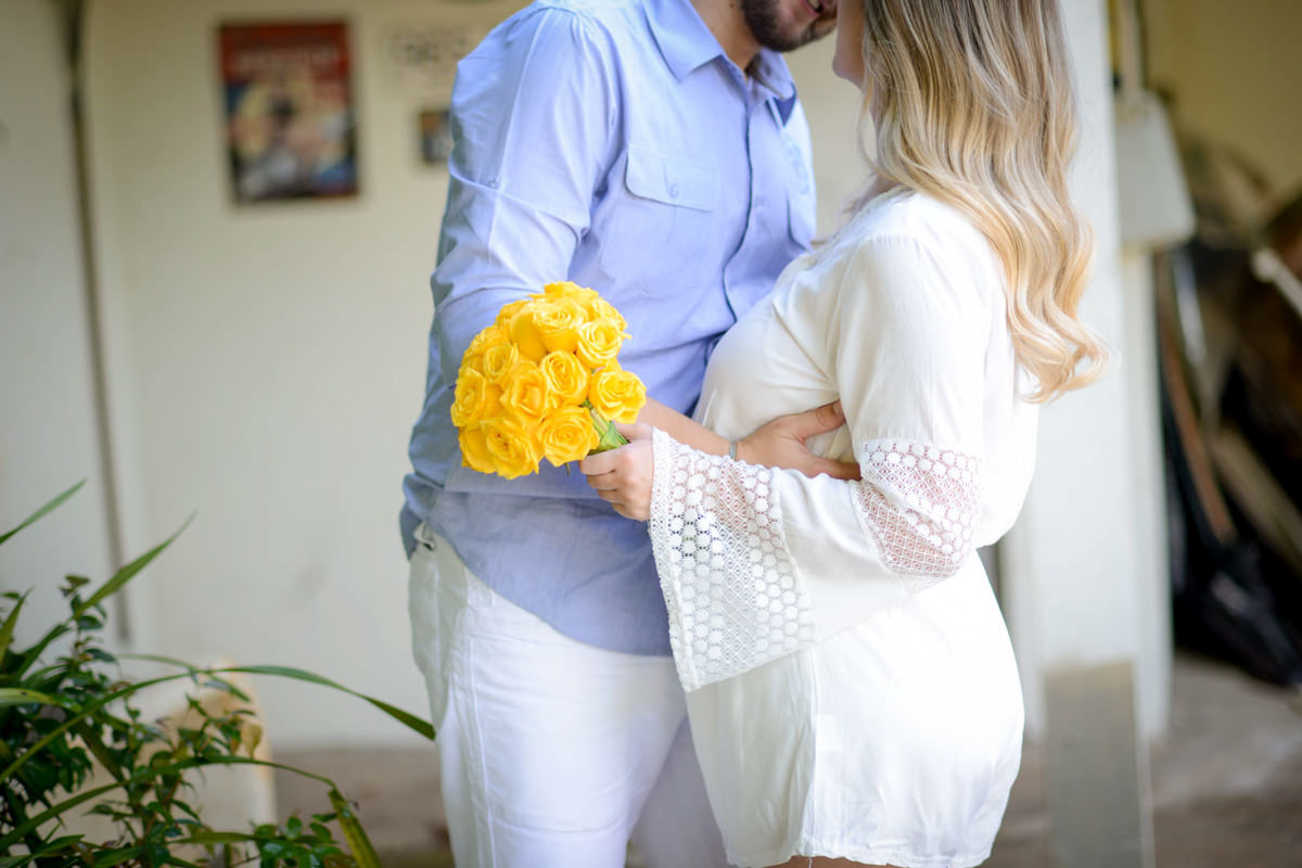 Ensaio de casal gestante em casa com cachorro fotografado pelo melhor fotógrafo de casamentos e ensaios de campo largo e Curitiba, Michel Druziki. Noivos abraçados e noiva com buquê amarelo
