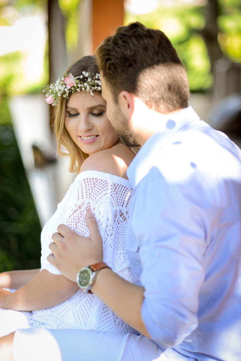 Ensaio de casal gestante em casa com cachorro fotografado pelo melhor fotógrafo de casamentos e ensaios de campo largo e Curitiba, Michel Druziki. Noiva com tiara de flores. Noivo dando beijo no rosto