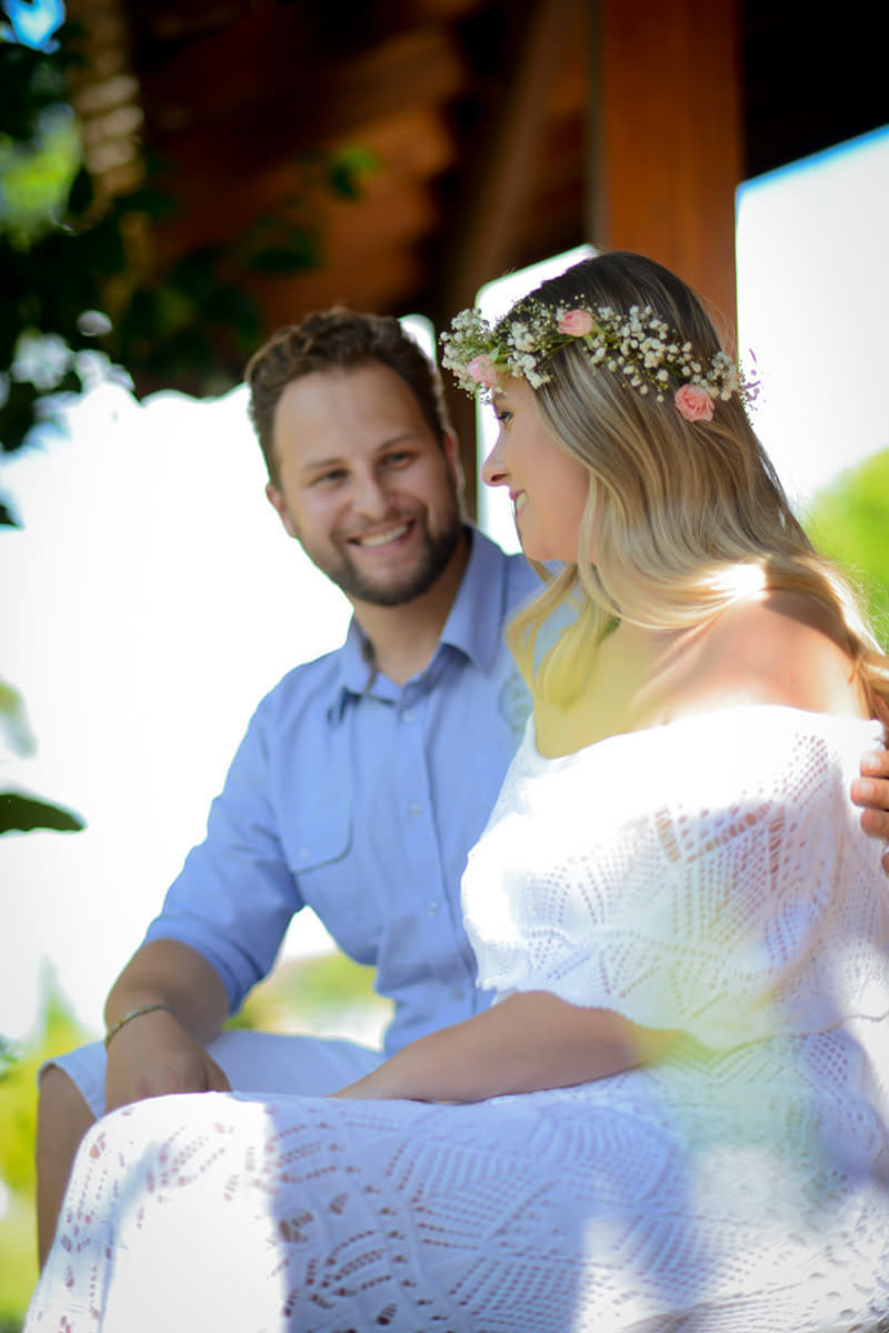 Ensaio de casal gestante em casa com cachorro fotografado pelo melhor fotógrafo de casamentos e ensaios de campo largo e Curitiba, Michel Druziki. Noivo olhando para a noiva com tiara de flores. 